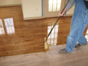 close up of worker finishing a floor with polyurethane