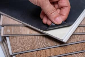 hand peeling back adheasive on luxury vinyl