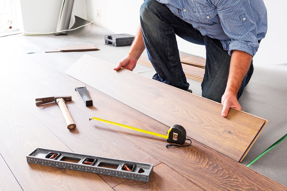 man installing laminate wood floor